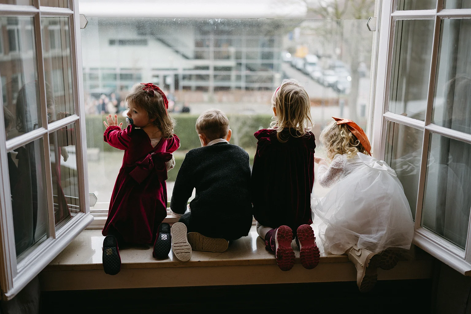 Children sitting by a window and watching a wedding day in Münster, NRW, Germany