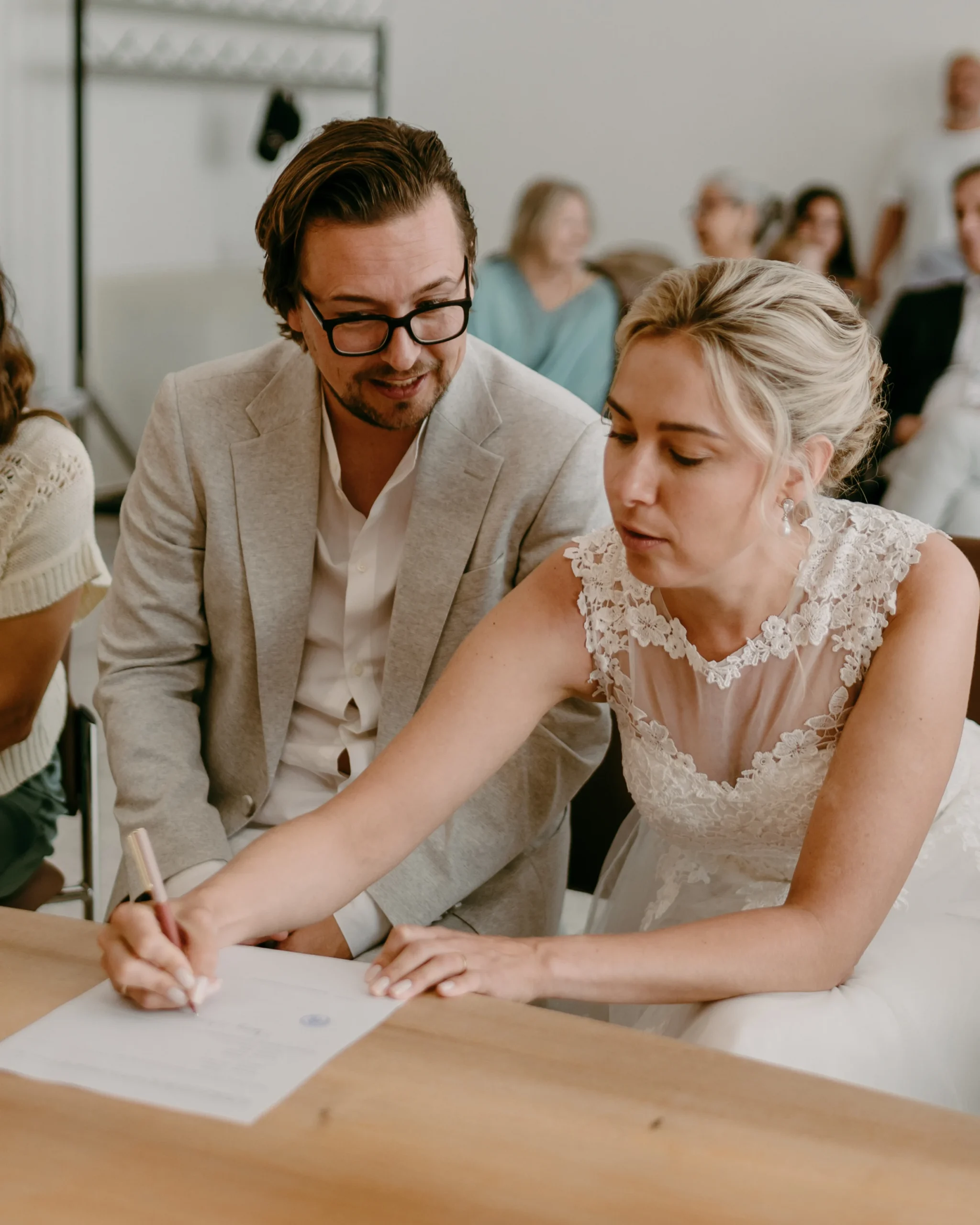 Brautpaar unterschreibt die Eheurkunde im Standesamt Köln, Braut und Bräutigam während der offiziellen Zeremonie ihrer intimen Hochzeit.