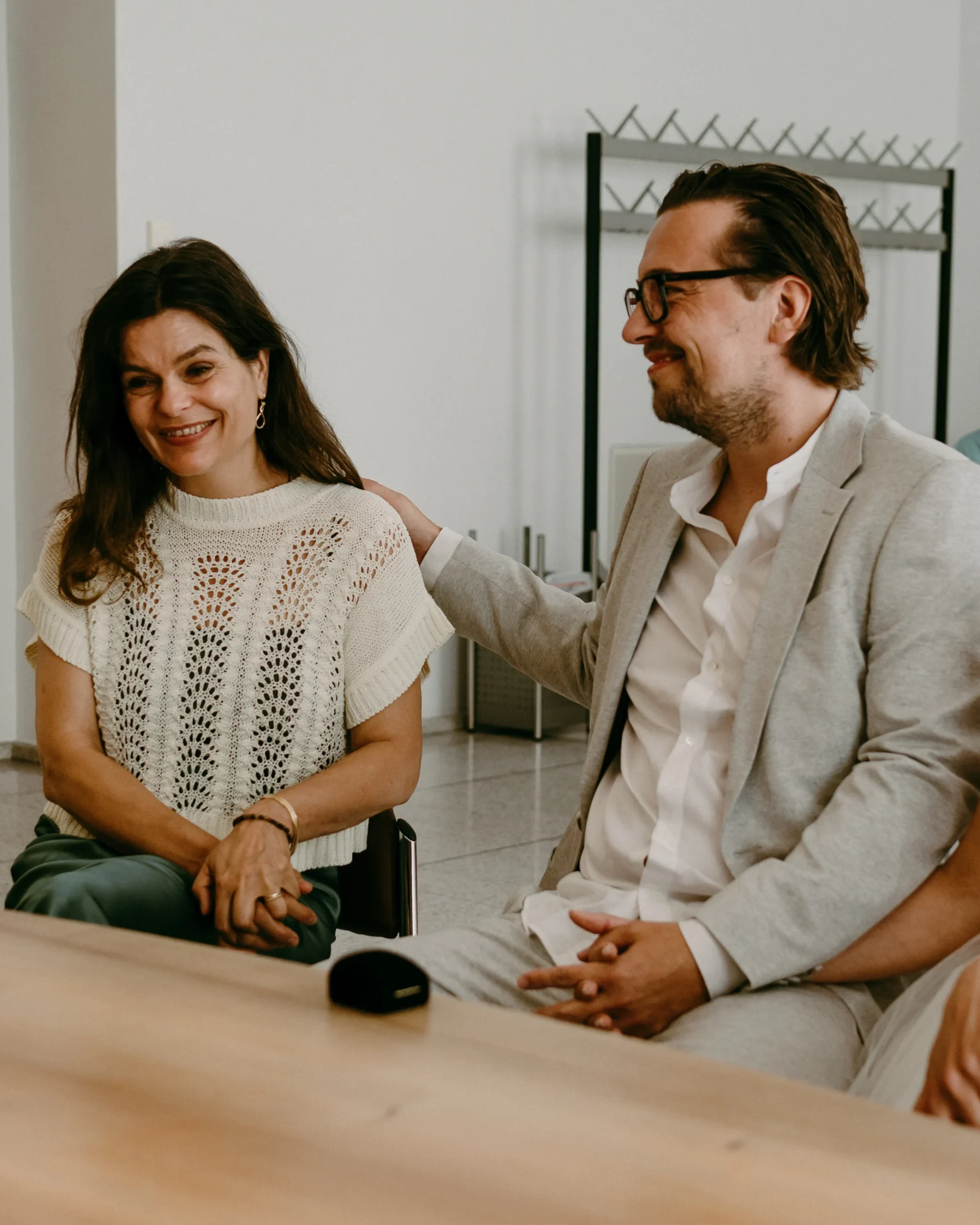 Nahaufnahme eines glücklichen, lächelnden Brautpaares und ihrer Trauzeugin während ihrer standesamtlichen Trauung im Kölner Standesamt.