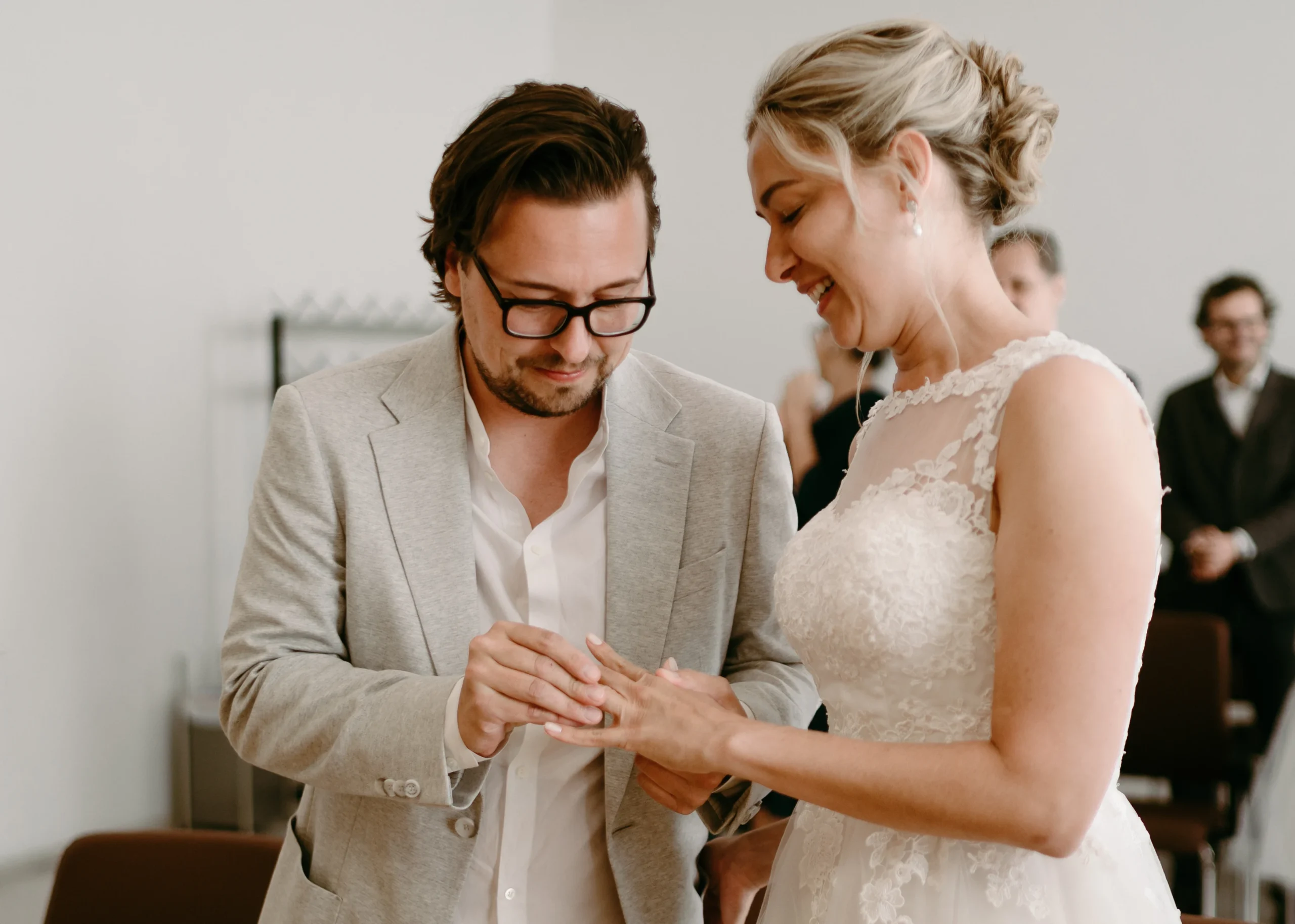 Ringtausch während der standesamtlichen Trauung in Köln: Der Bräutigam steckt der Braut den Ehering an den Finger.