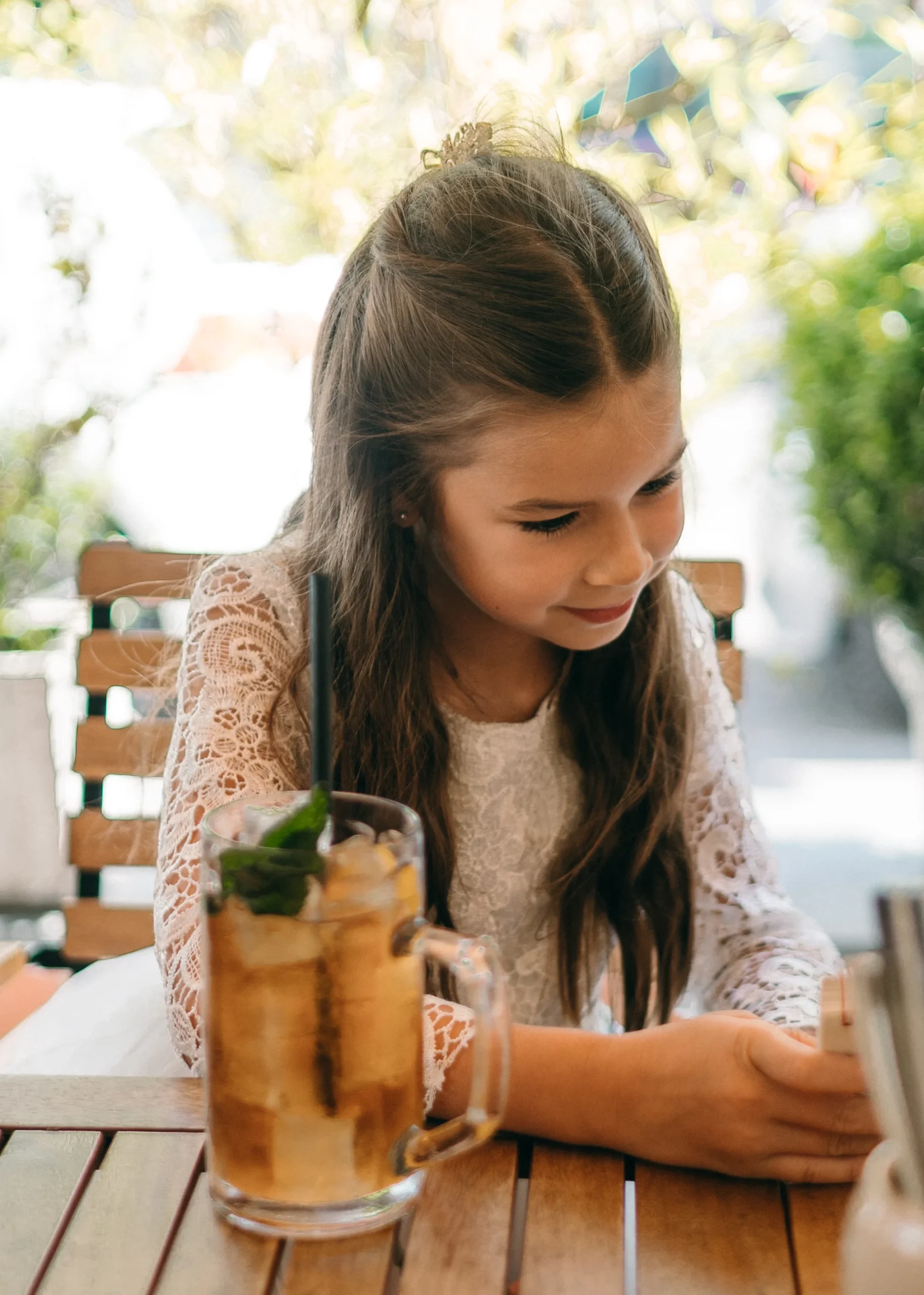 Blumenmädchen im Spitzenkleid bei einer Hochzeit im Freien in Köln