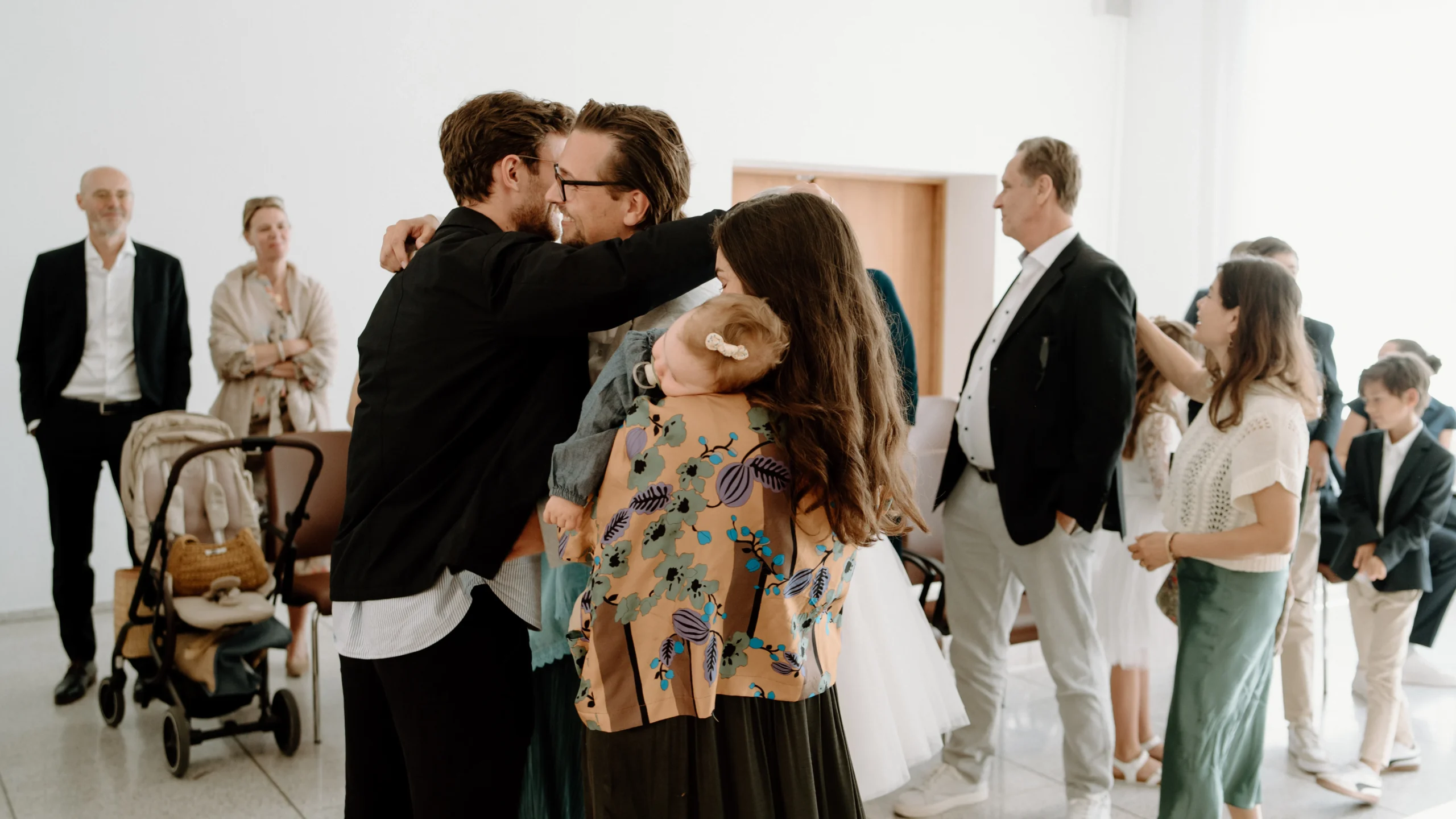 Bräutigam umarmt einen Gast während der Glückwünsche im Standesamt Köln, emotionale Feier nach der standesamtlichen Trauung mit Familie und Freunden.