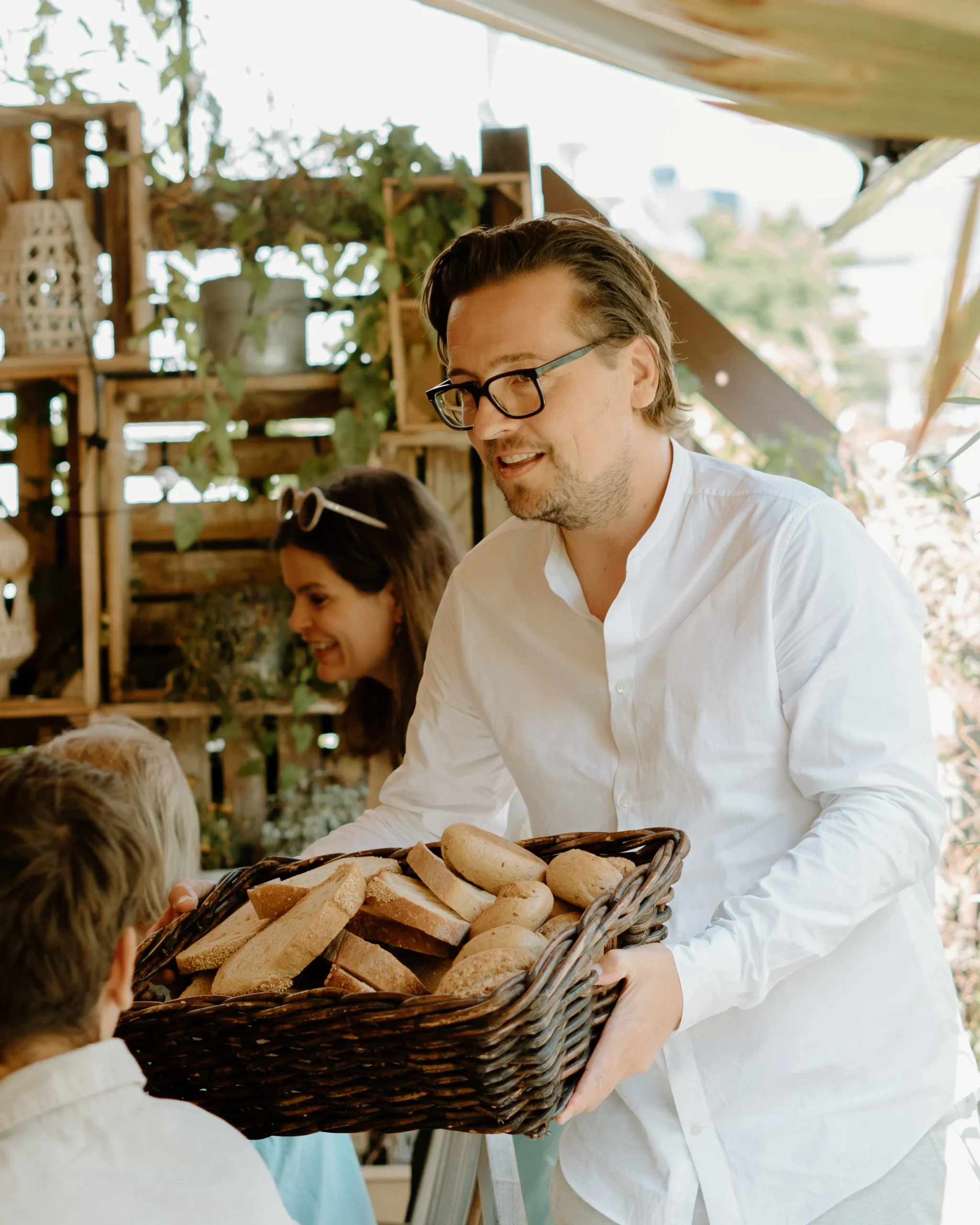 Bräutigam reicht Brotkorb während der Hochzeitsfeier in Köln