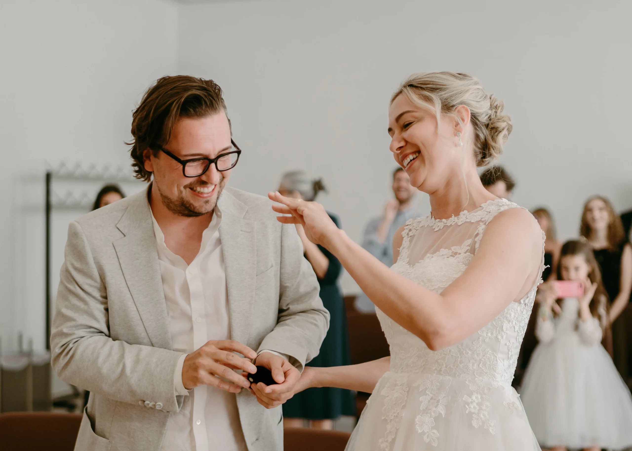Fröhliches Brautpaar lacht gemeinsam bei der standesamtlichen Trauung in Köln – ein authentischer Moment während der Zeremonie.