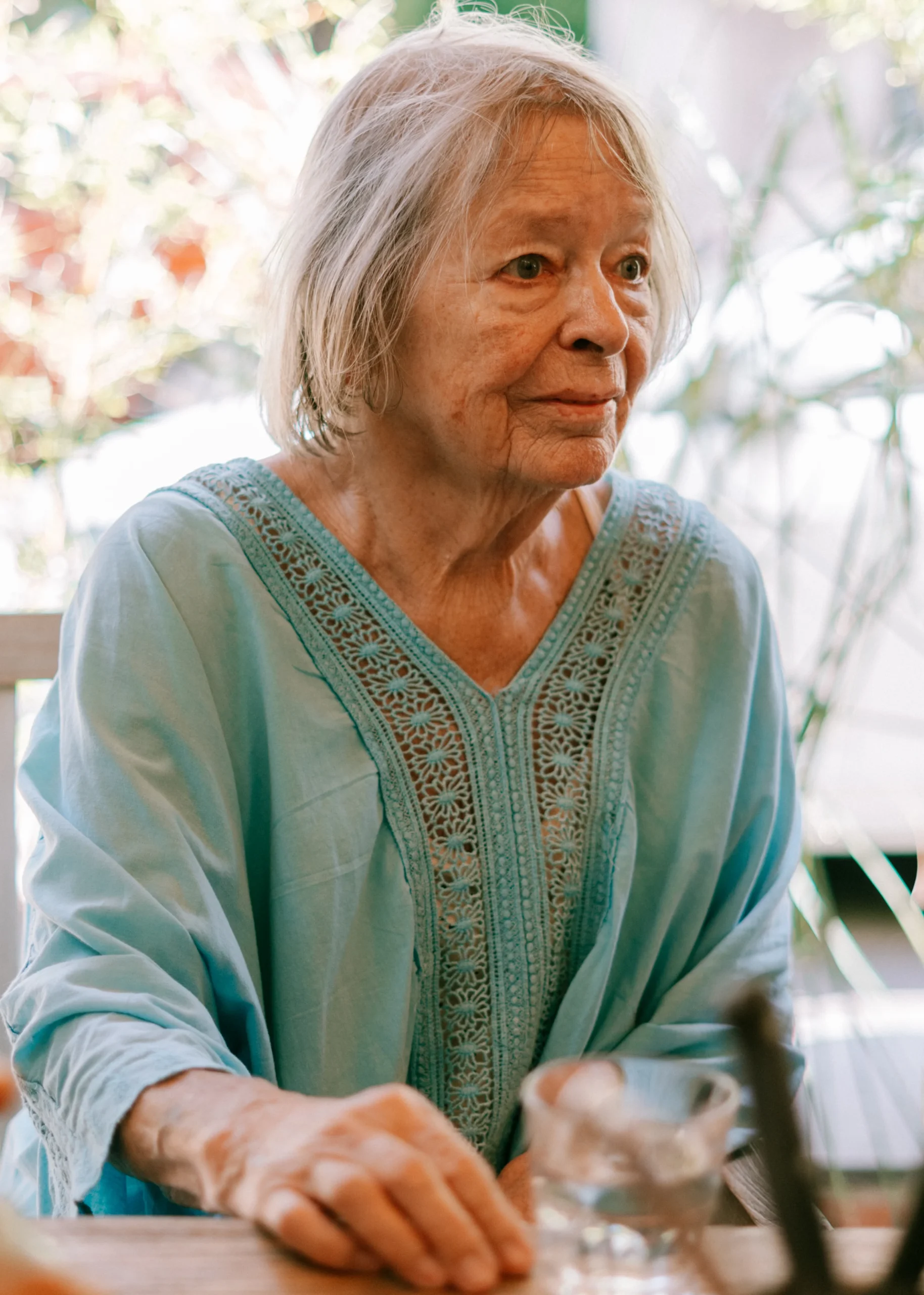 Ältere Hochzeitsgästin im eleganten blauen Kleid blickt zur Seite bei einer Feier in Köln