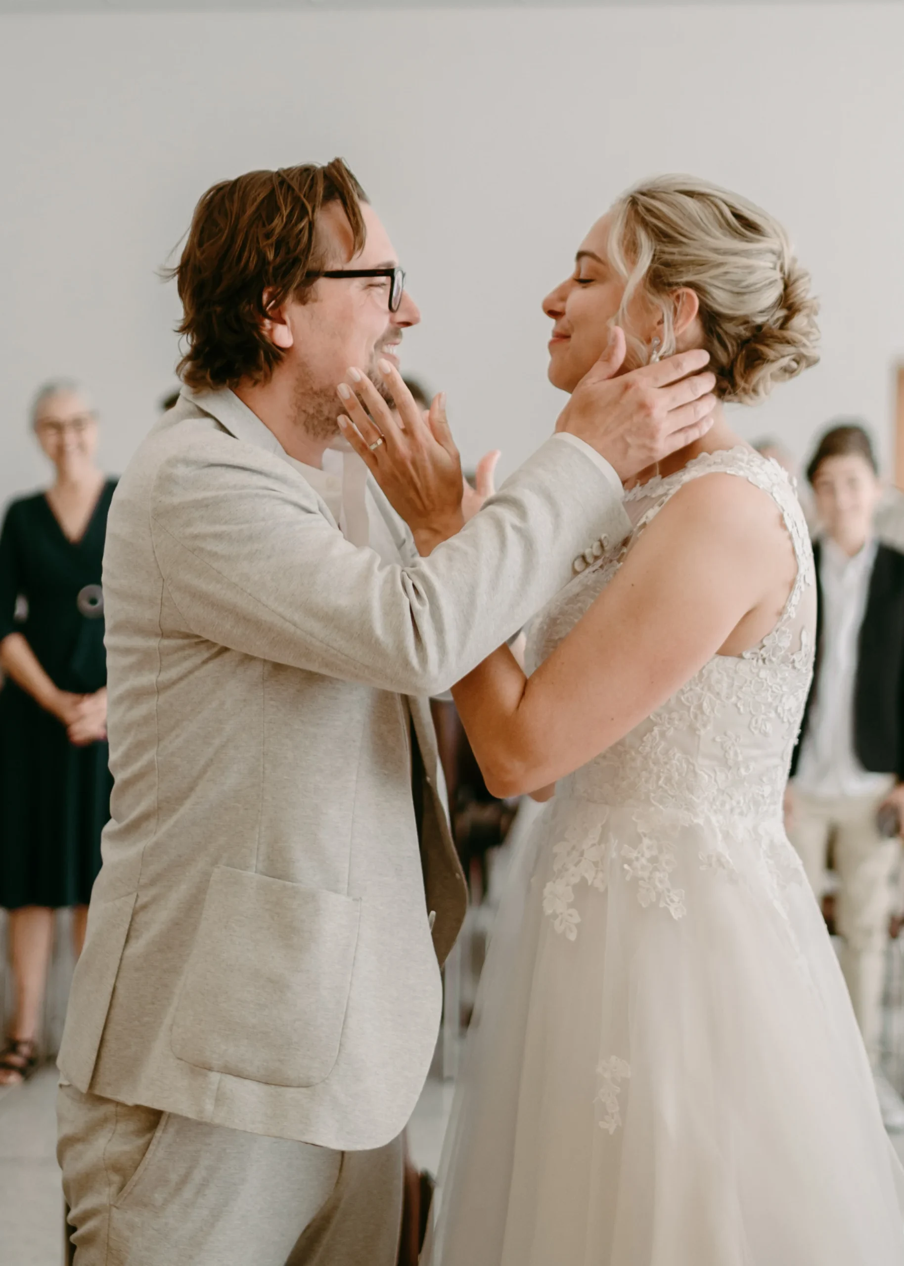 Inniger Moment während der standesamtlichen Trauung in Köln: Das Brautpaar sieht sich liebevoll an und hält sich das Gesicht.